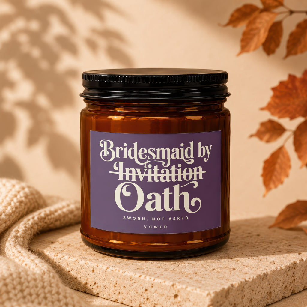 Brown glass candle with purple label reading "Bridesmaid by Invitation Oath"