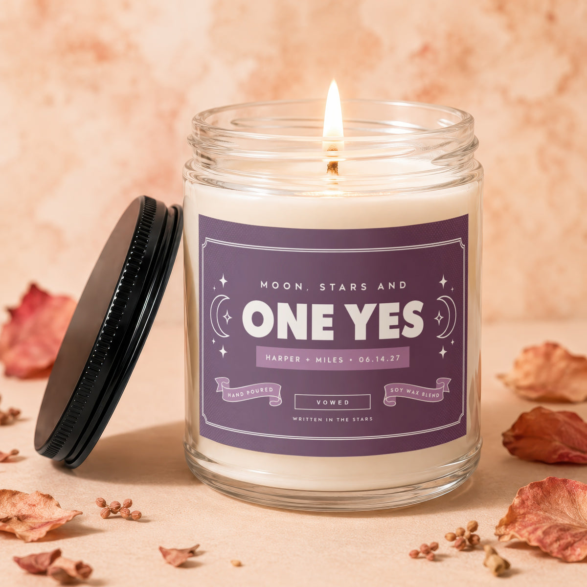 Lit candle with "ONE YES" text and "Harper + Miles 06.14.27" on label.