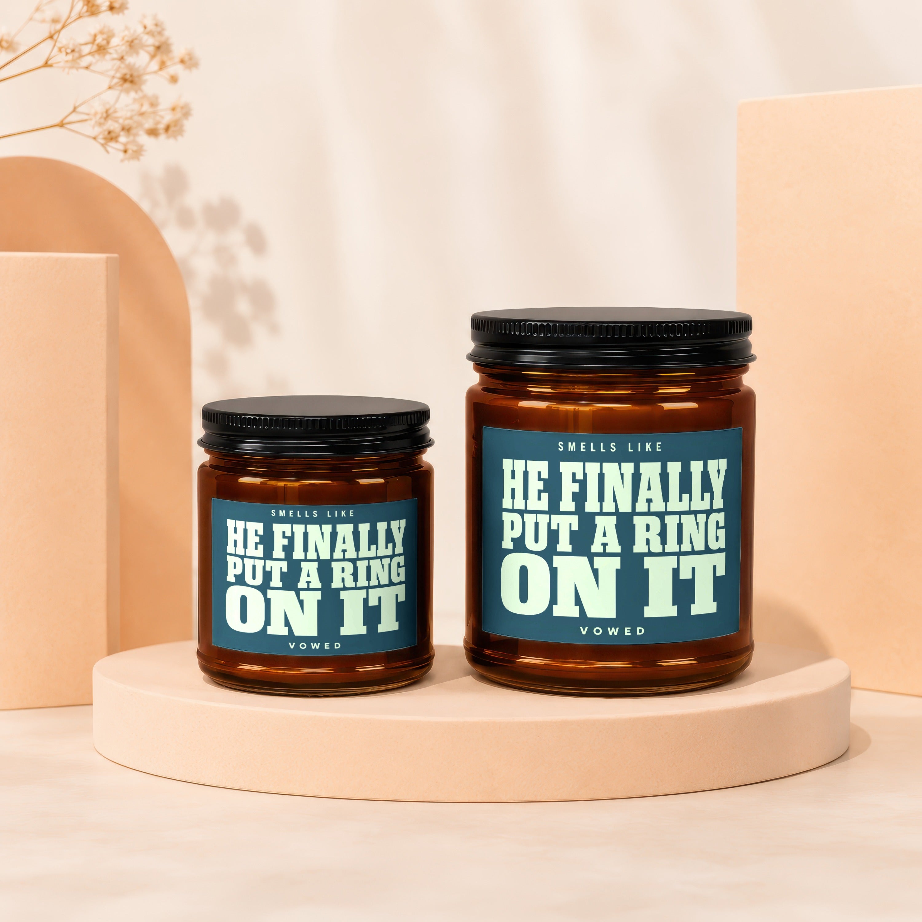 Two amber jars with black lids, labeled "Smells Like He Finally Put A Ring On It".