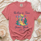 Pink t-shirt with "Reckless in Texas Olivia's Bach Austin, TX Summer 2026" text and western graphics.