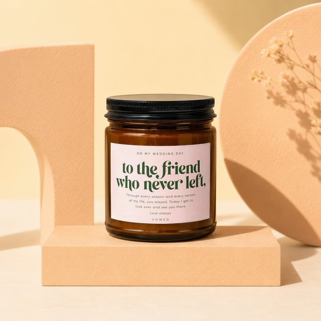 Amber glass candle with a black lid and a pink label that reads "to the friend who never left".