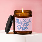 Amber candle with pink label reading "She Said Maybe Yes And She Meant It Vowed".