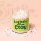 Glass jar candle with lit wick, "Happily Ever After Cozy Vowed" text.