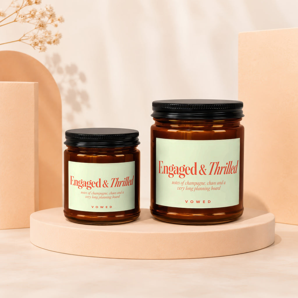 Two amber glass candles with black lids and "Engaged & Thrilled" labels.