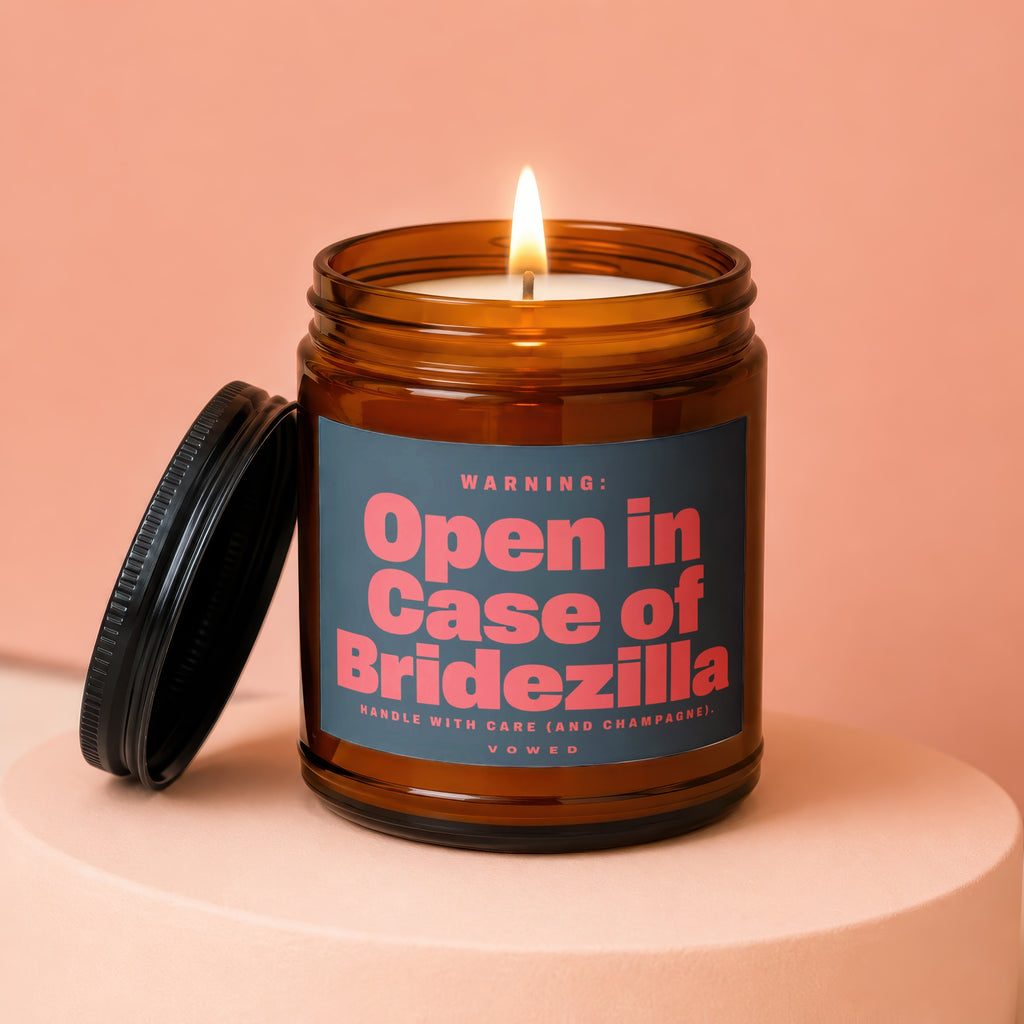 Amber jar candle with lit wick and black lid, reading "Open in Case of Bridezilla".