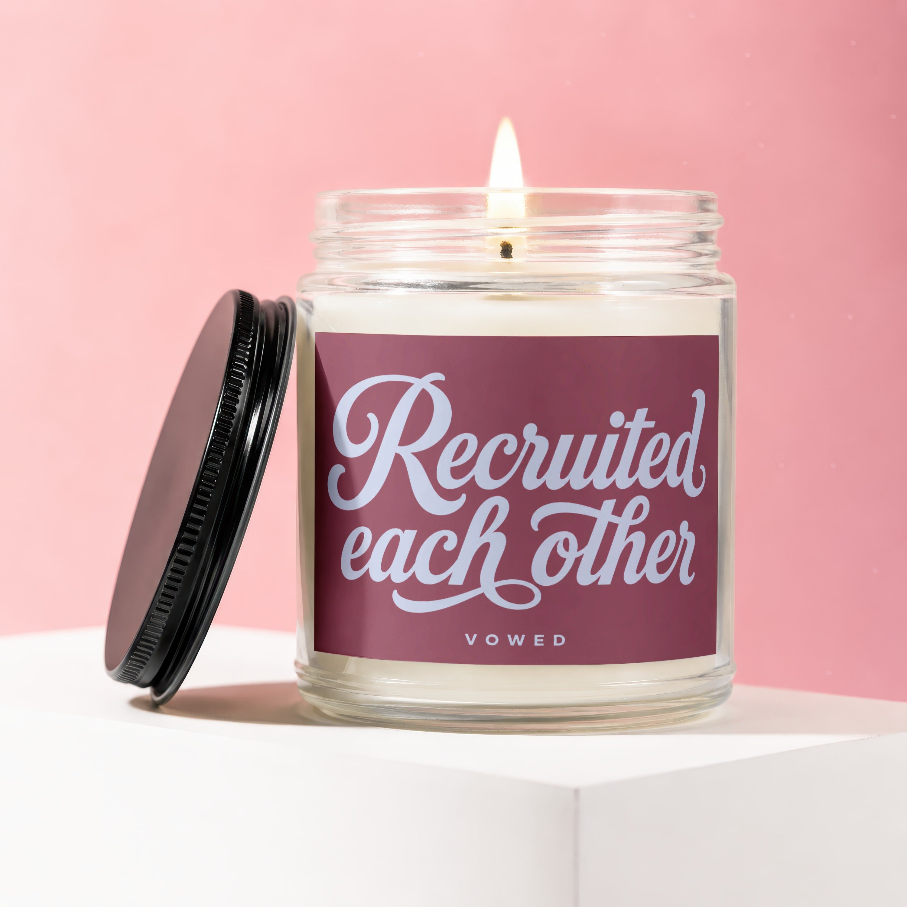 Candle with label saying "Recruited each other VOWED" with lid off.