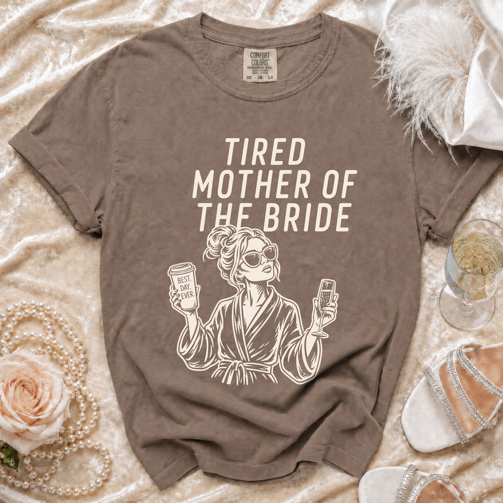 T-shirt with "Tired Mother of the Bride" text and graphic, surrounded by decorative items.