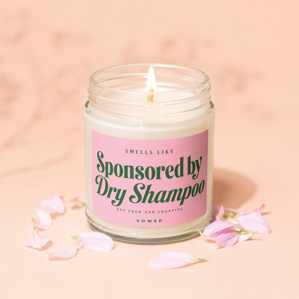 Vowed candle "Sponsored by Dry Shampoo" with pink petals.