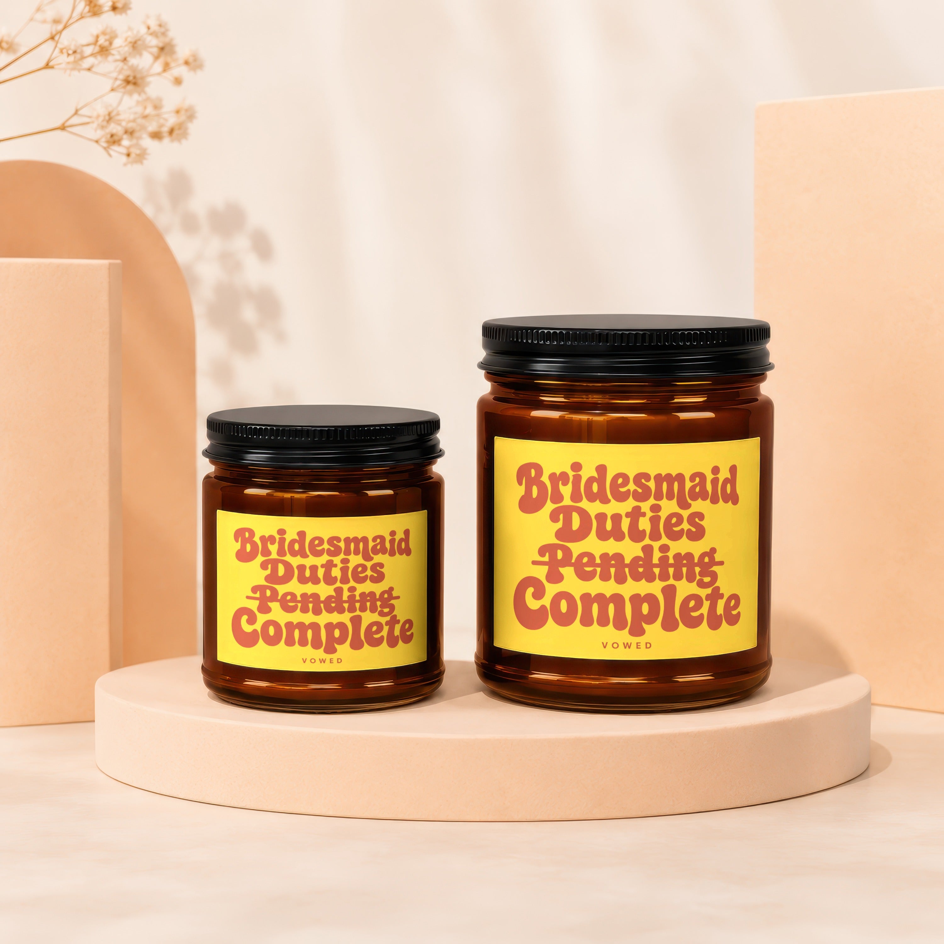Two amber candles with yellow labels saying "Bridesmaid Duties Pending Complete".