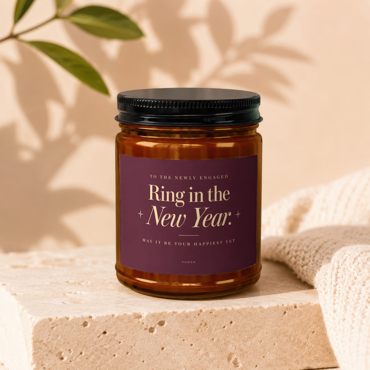 Amber jar candle with dark label reading "Ring in the New Year" for the newly engaged.