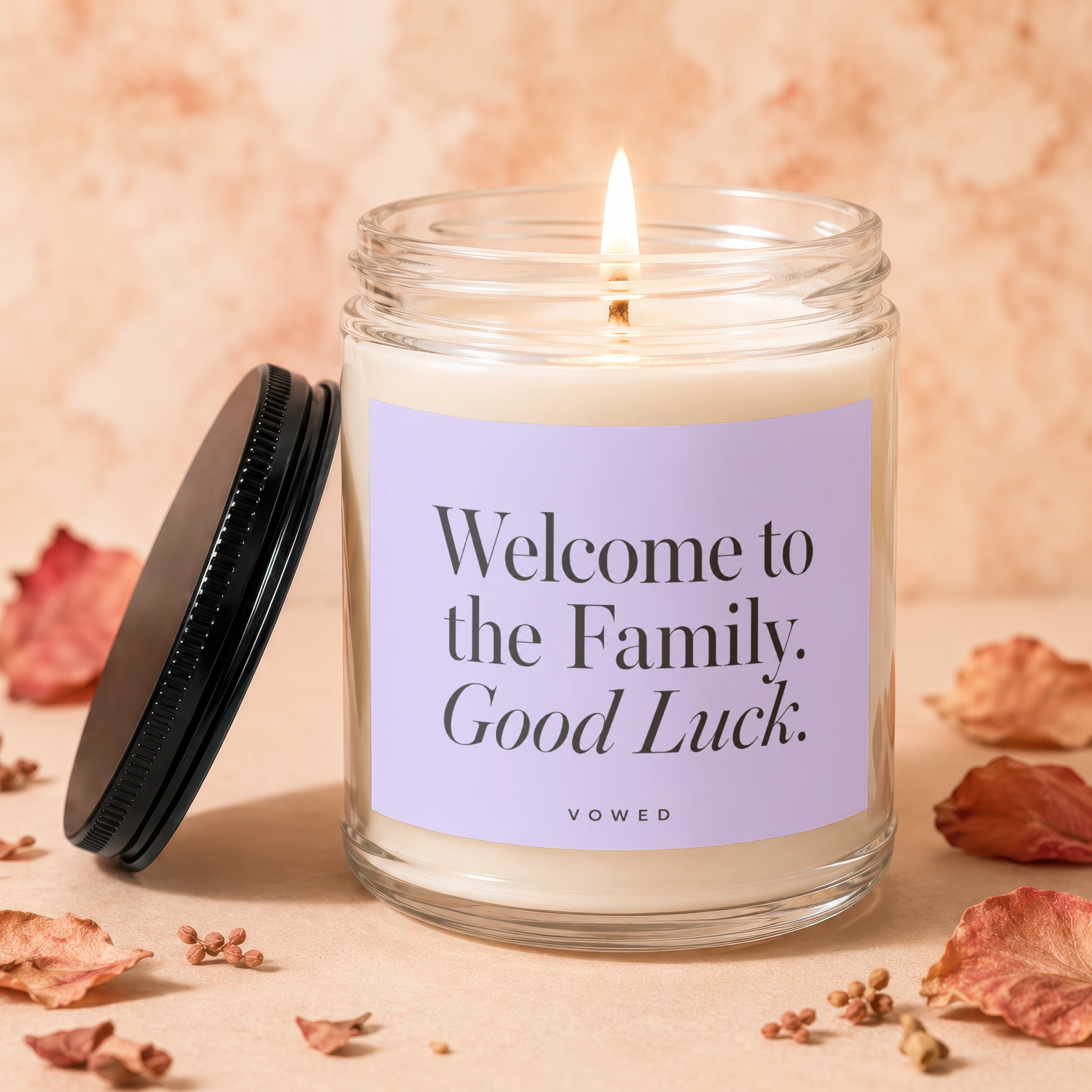 Candle with "Welcome to the Family. Good Luck." text on a lavender label.