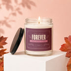 Lit candle with "Forever One Love Story Vowed" label on pink background with autumn leaves.