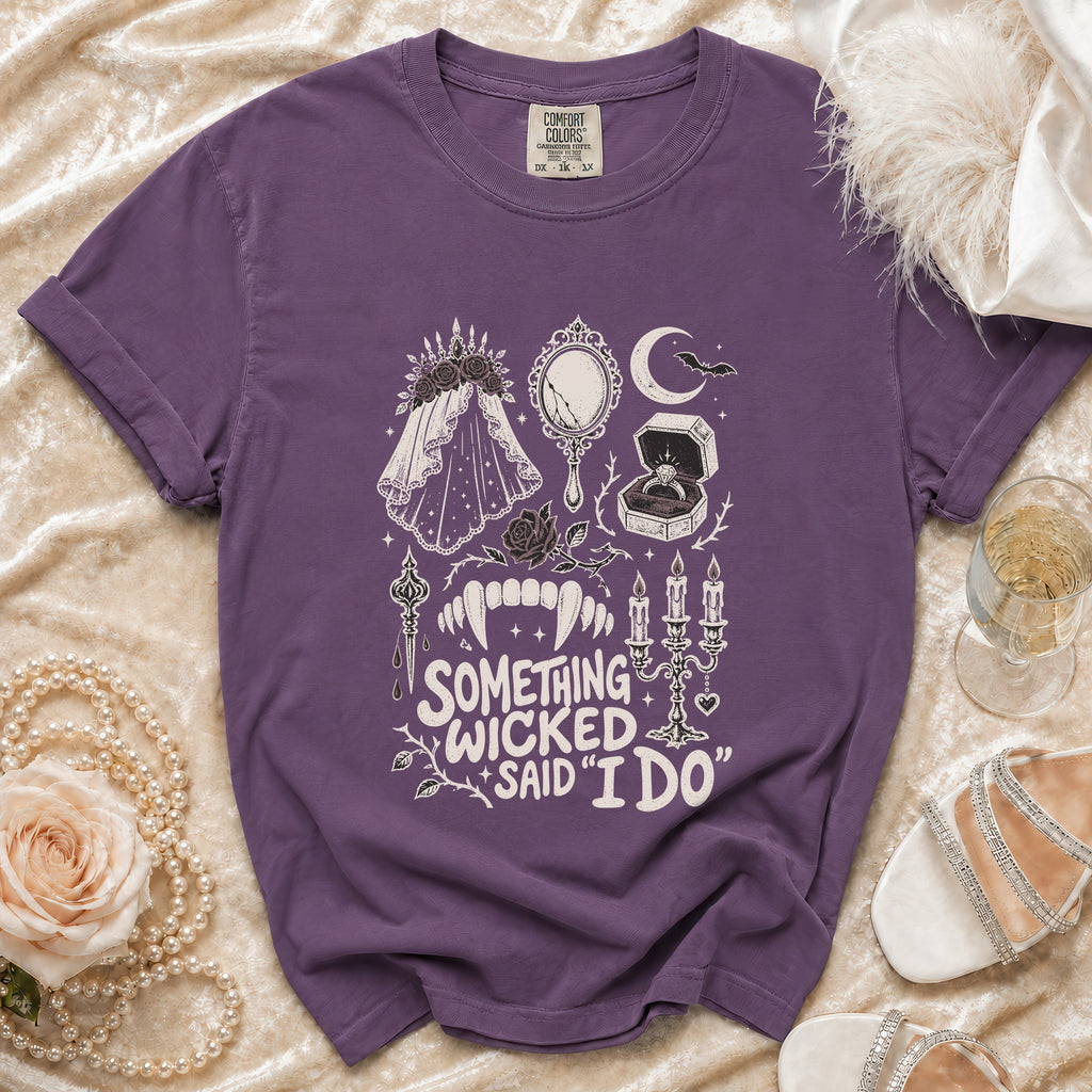 Purple t-shirt with "Something Wicked Said I Do" text and gothic wedding graphics.