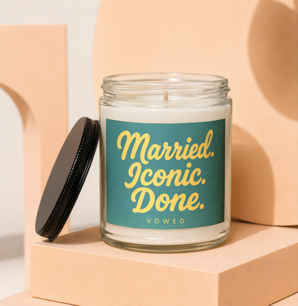 Glass candle with teal label reading "Married. Iconic. Done. VOWED."