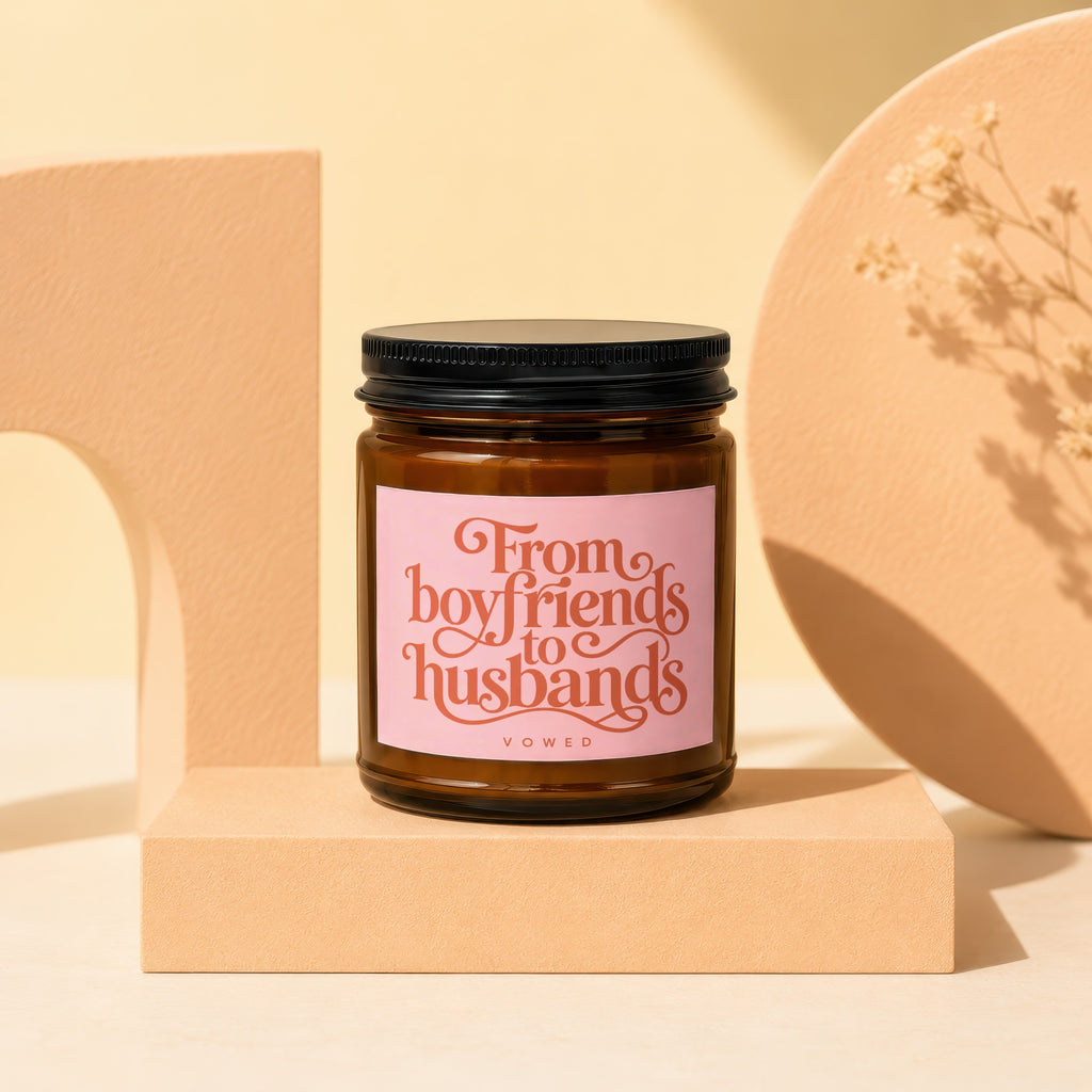 Amber glass candle with pink label reading "From boyfriends to husbands VOWED".