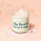 Candle with text "The Best Is Yet to Come", surrounded by petals.
