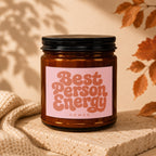 Brown candle with pink label reading "Best Person Energy" and "VOWED".