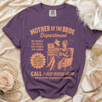 Purple t-shirt with "Mother of the Bride Department" graphic and humorous text.