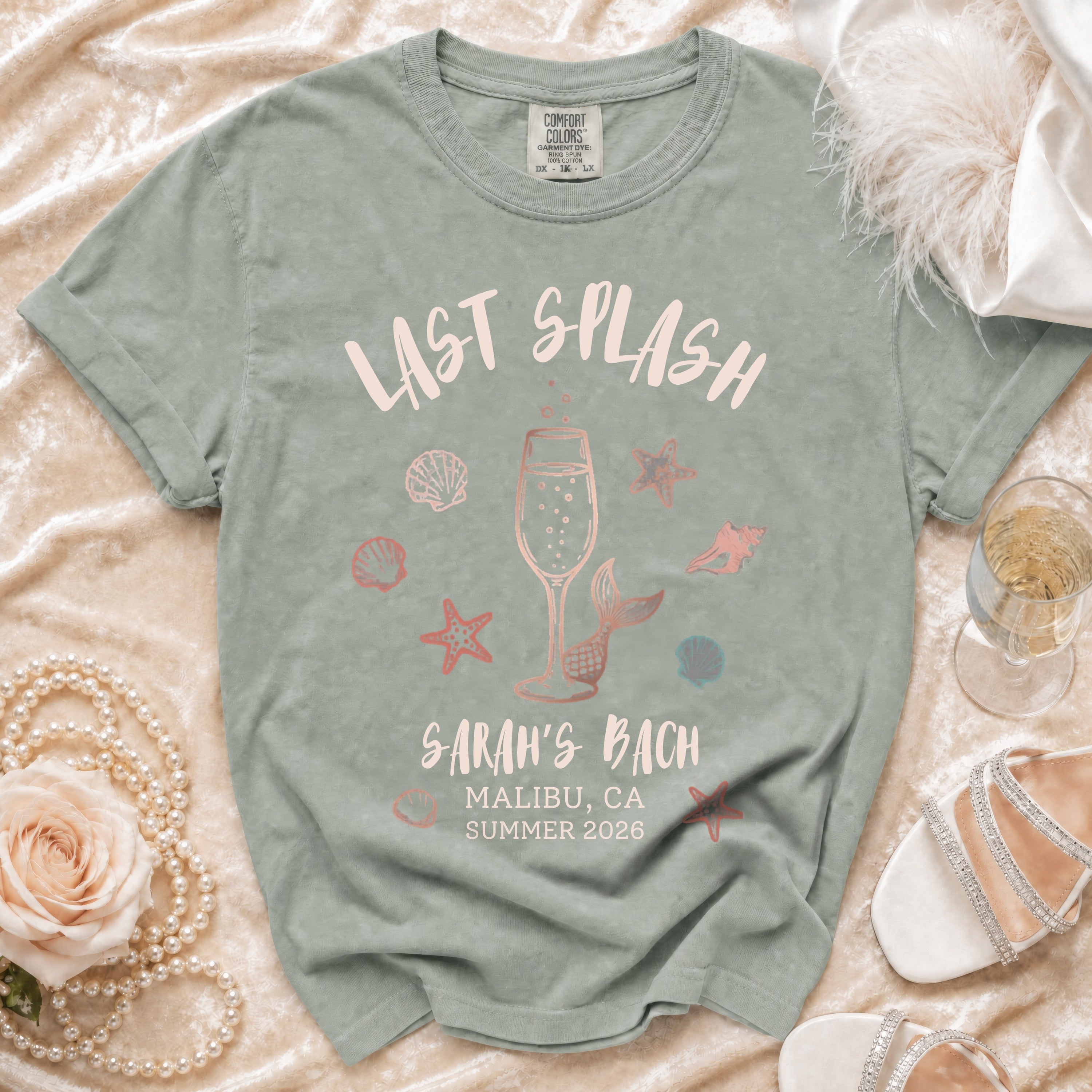 "Last Splash Sarah's Bach" text on a sage green t-shirt with seashells.