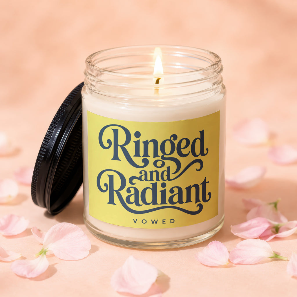 Candle labeled "Ringed and Radiant VOWED" with black lid and pink petals.