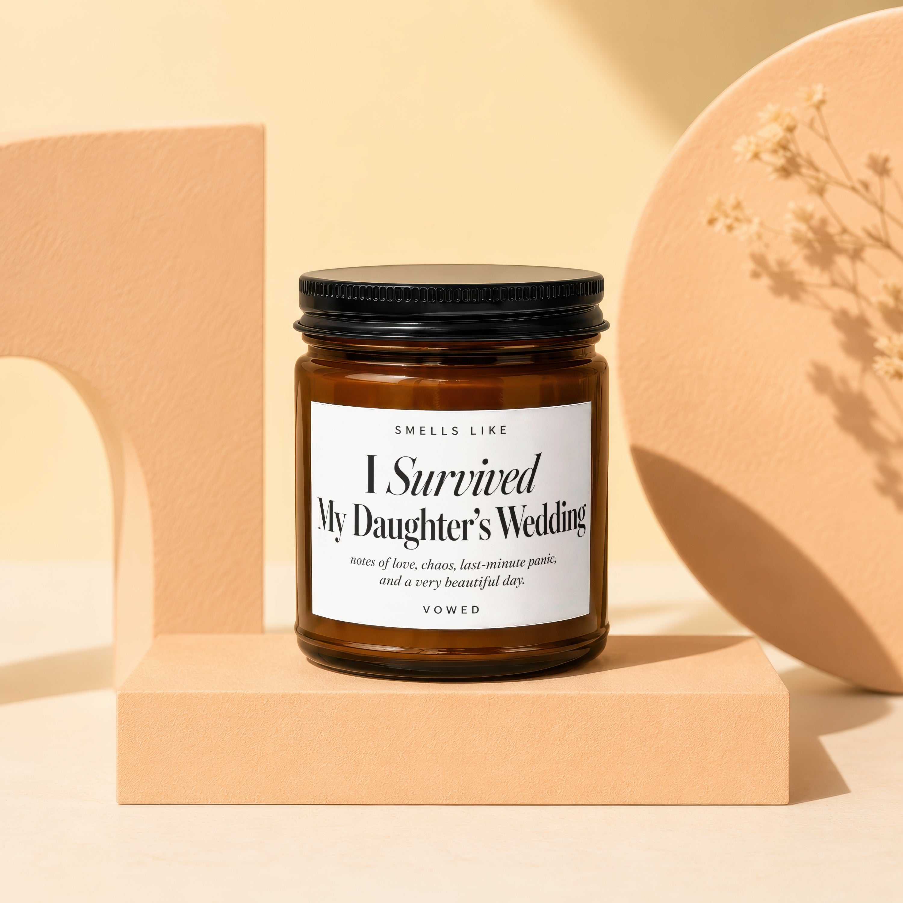 Amber jar candle with black lid, "I Survived My Daughter's Wedding" label.