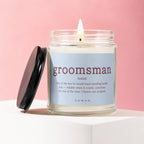 Glass candle labeled "groomsman" with a definition, on a pink background.