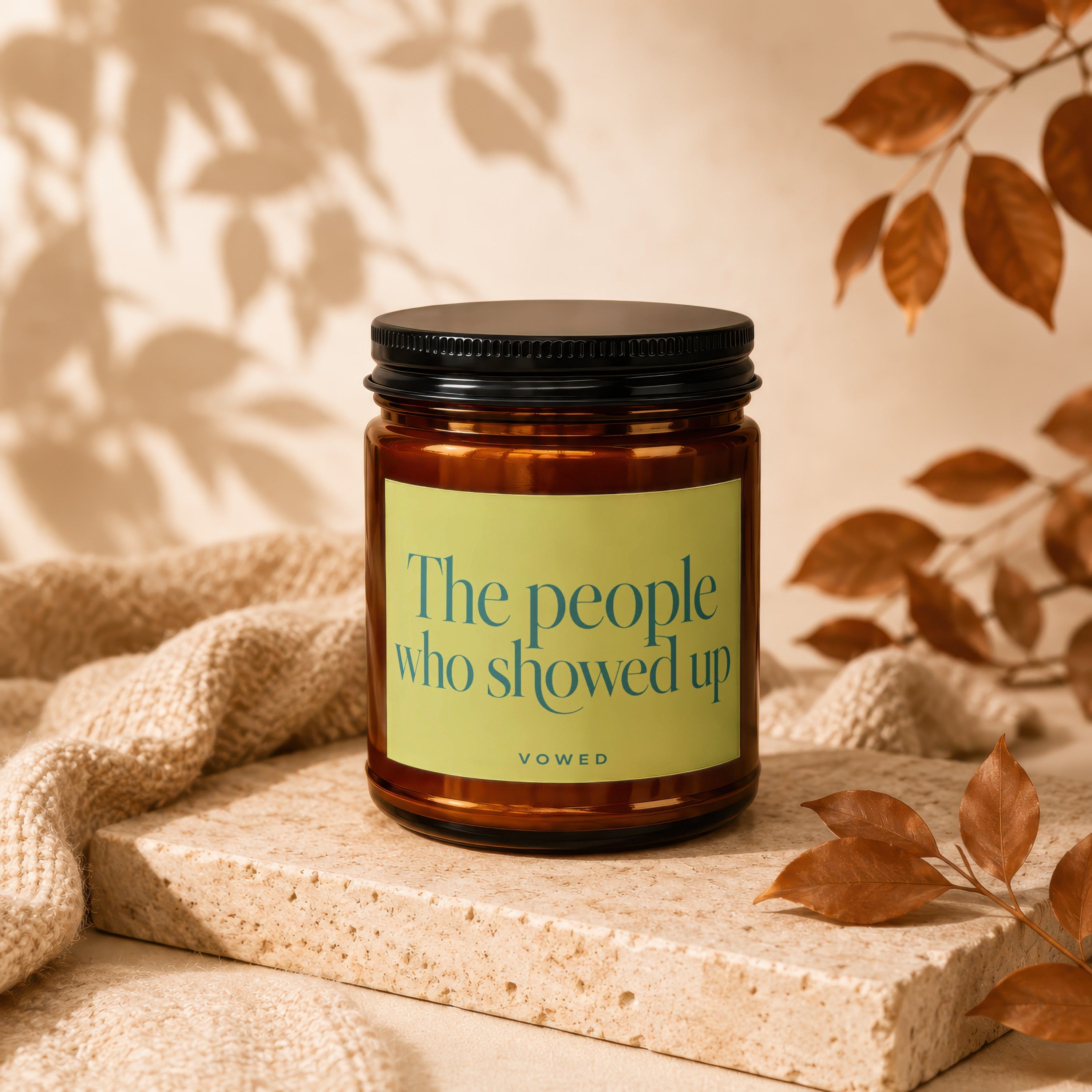 Candle with black lid and light green label reading "The people who showed up" by VOWED.