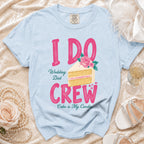 Light blue t-shirt with bold pink "I DO CREW" text and a slice of wedding cake.