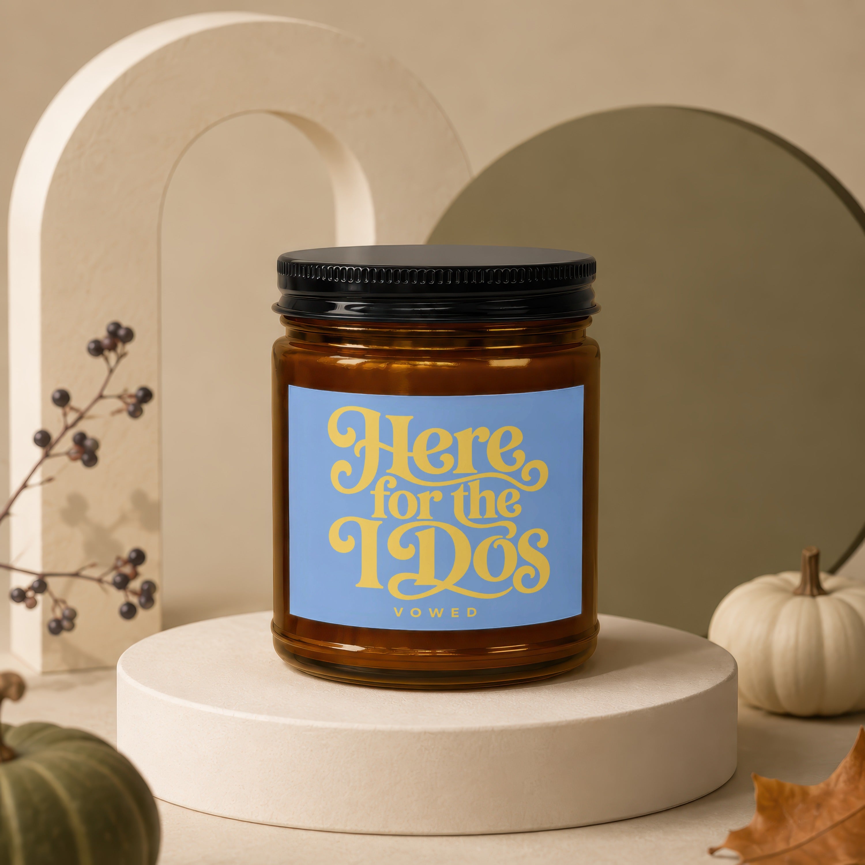 Amber jar candle with "Here for the DOs" text, on a display stand.