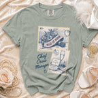 Sage green t-shirt with "Maid of Honor" and "Chief Crisis Manager" graphics.
