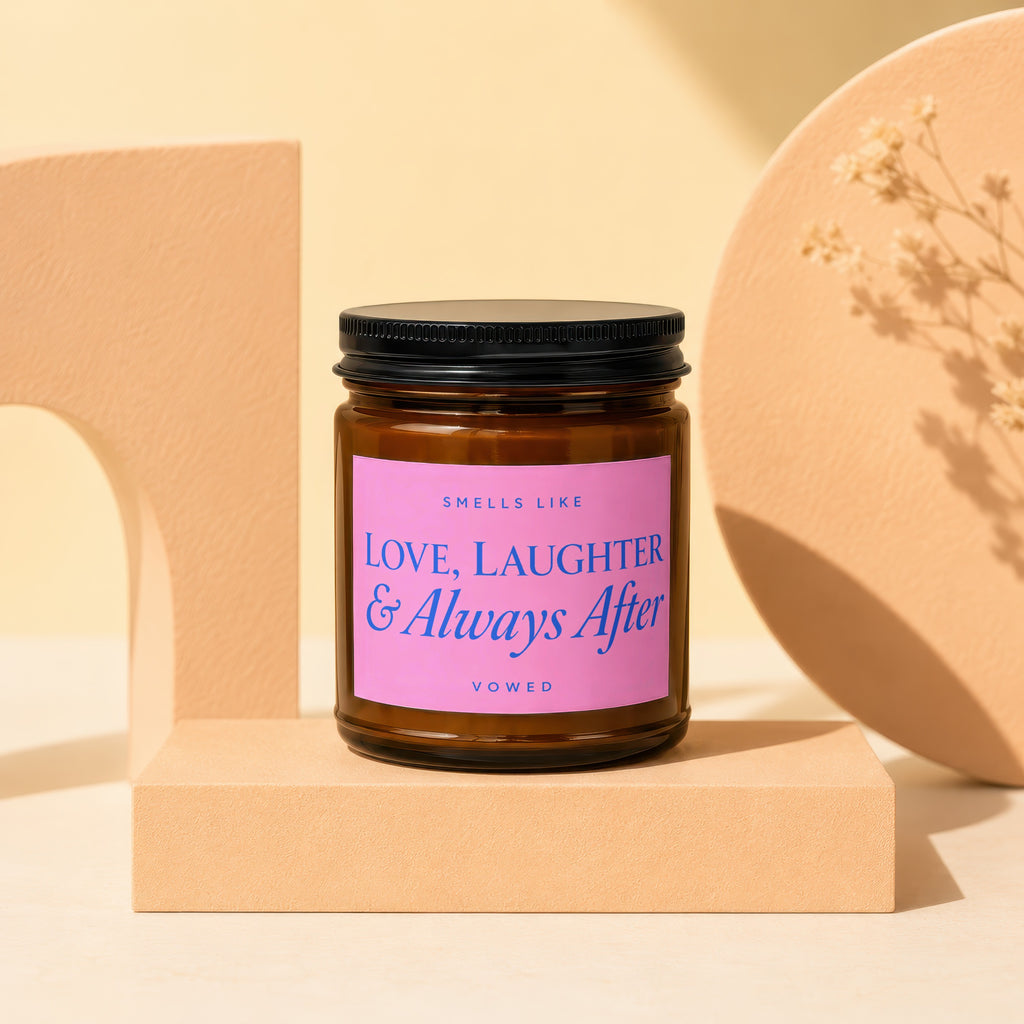 Brown candle with pink label that reads "Smells Like Love, Laughter & Always After Vowed".