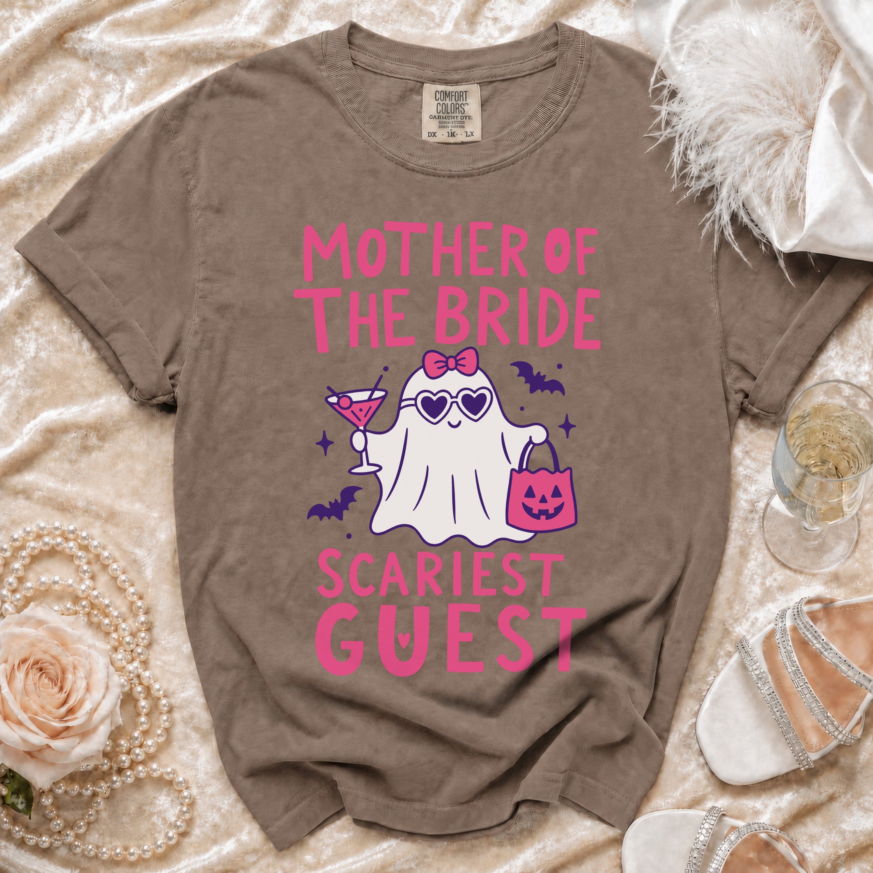 Brown Comfort Colors t-shirt with pink "Mother of the Bride Scariest Guest" text and ghost graphic.