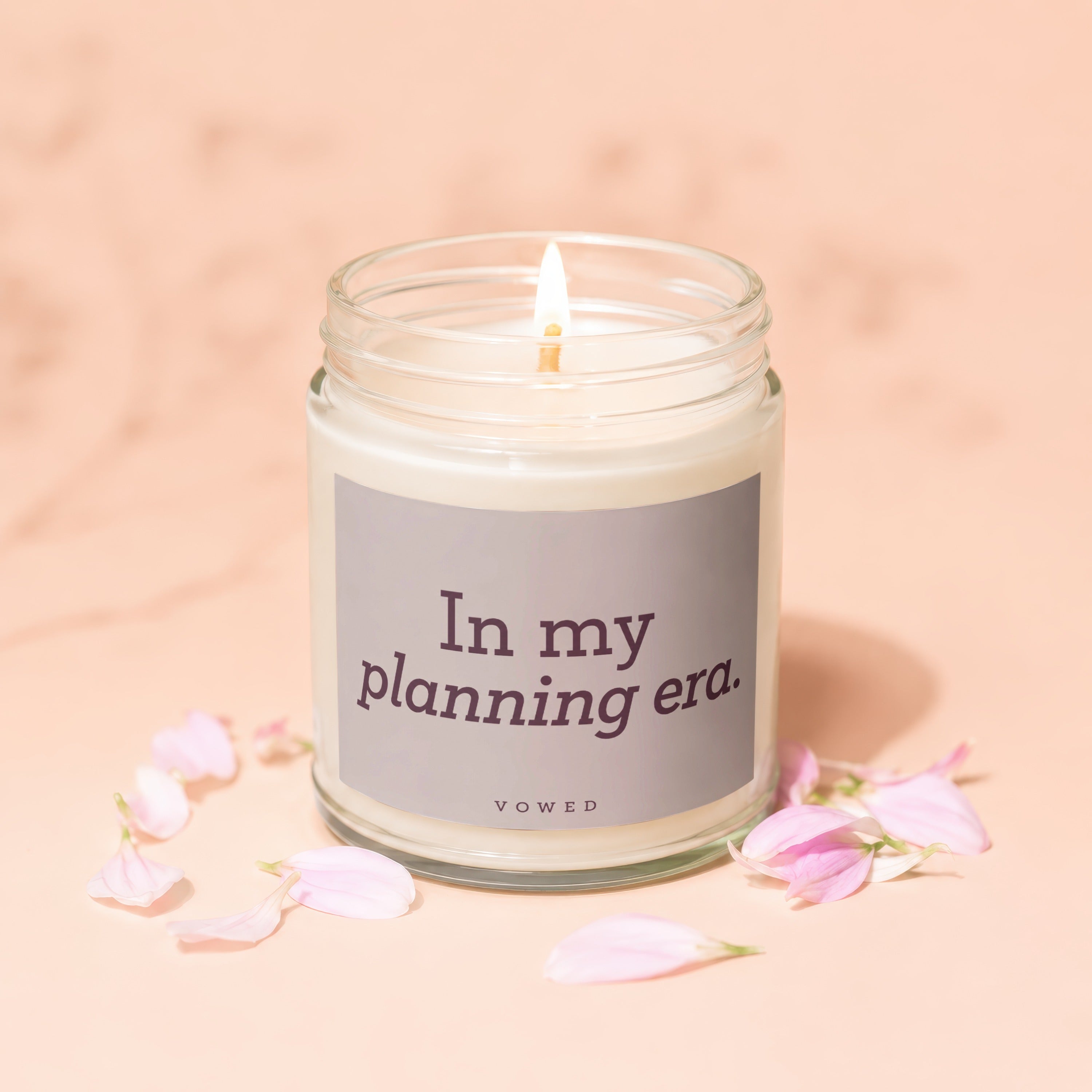 Candle with "In my planning era." text and pink petals on a peach background.