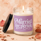 Lit candle in a glass jar with lavender label reading "Married my person VOWED".