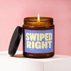 Amber jar candle with burning wick and blue label that reads "SWIPED RIGHT BEST DECISION EVER VOWED".