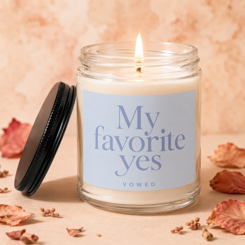 Candle with lit wick and label that reads "My favorite yes VOWED".