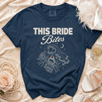 Navy t-shirt with "THIS BRIDE Bites" graphic featuring vampire fangs, rose, and ring.