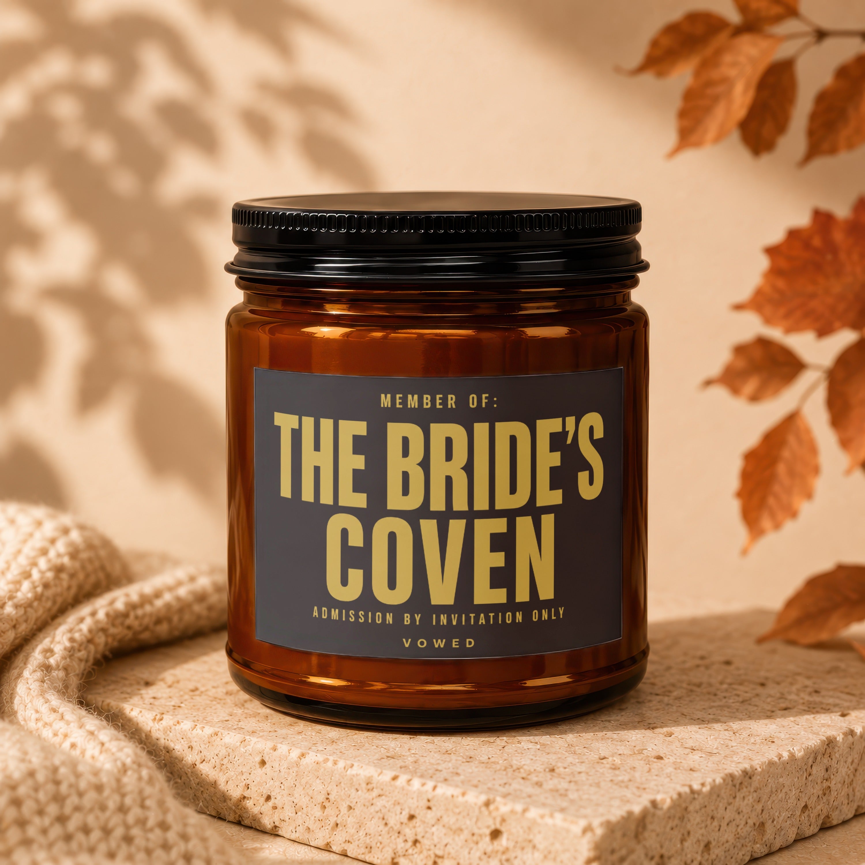 Amber candle with black lid, label reads "The Bride's Coven"
