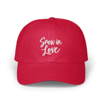 A solid red baseball cap featuring the white embroidered text Snow in Love on the front.