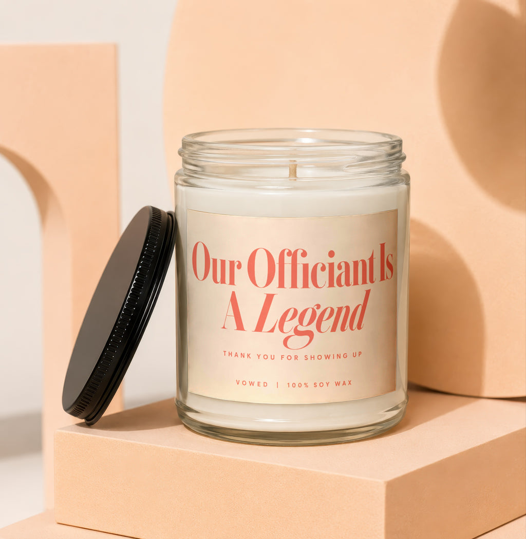 Glass candle with "Our Officiant Is A Legend" text, 100% soy wax.