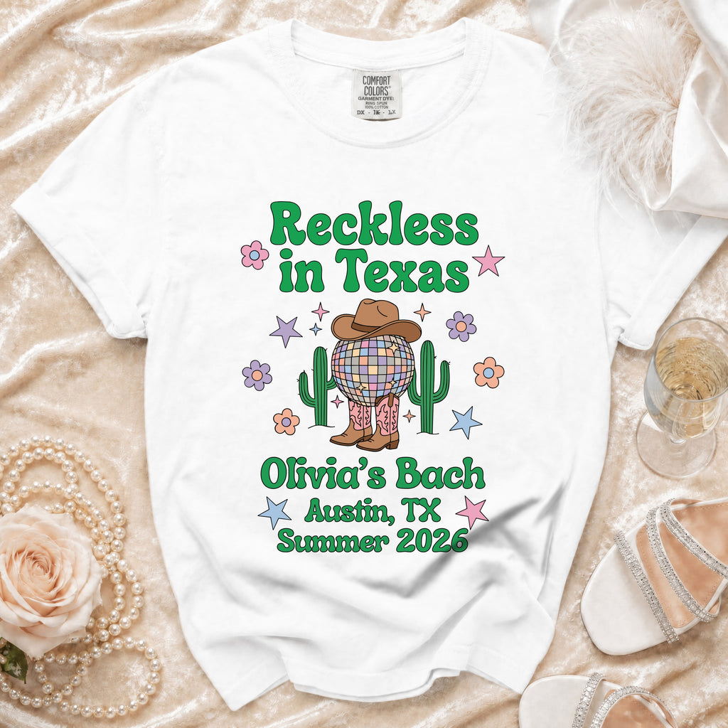 White t-shirt with "Reckless in Texas" and "Olivia's Bach Austin, TX Summer 2026" text.