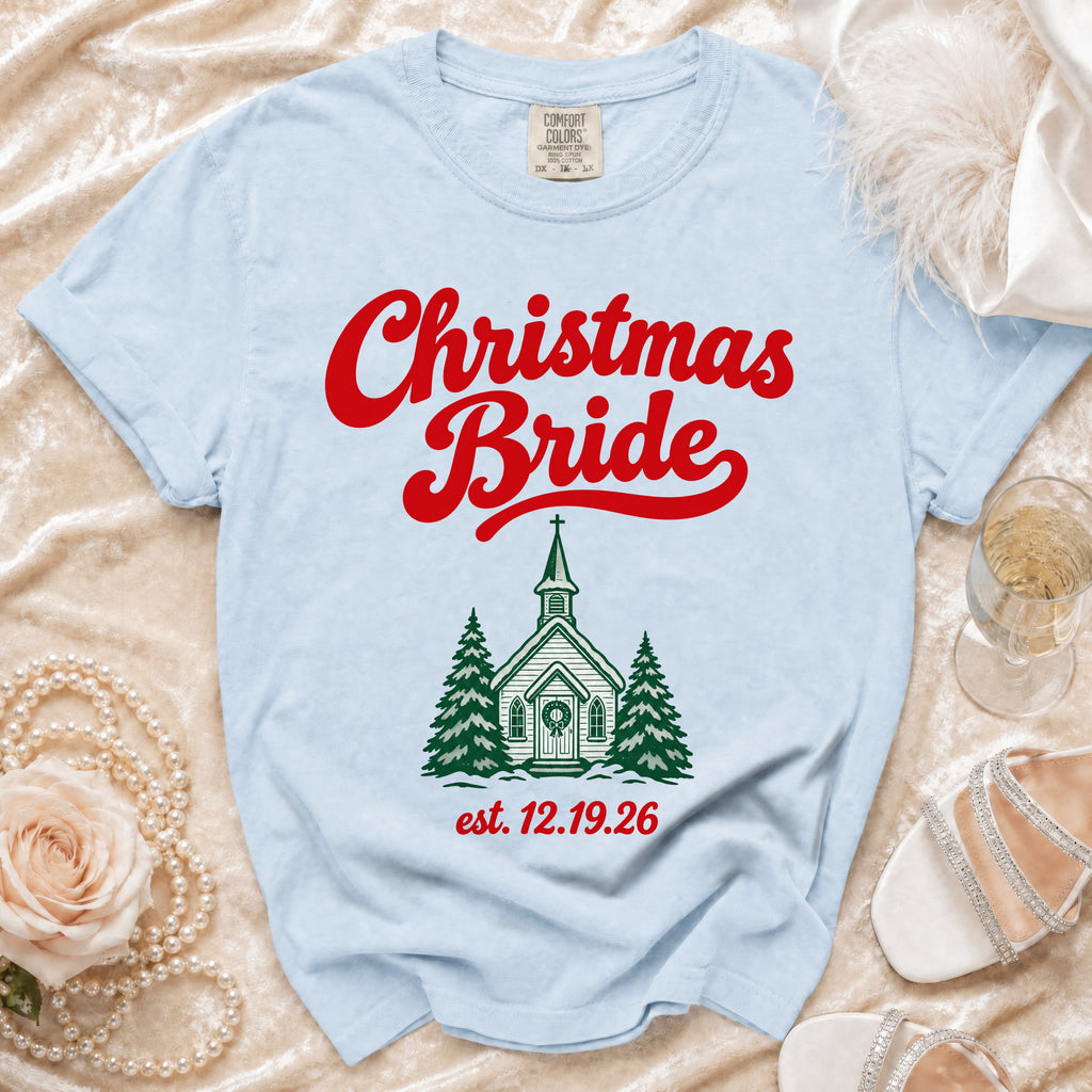 Light blue t-shirt featuring the red text Christmas Bride and a green church graphic with est. 12.19.26.