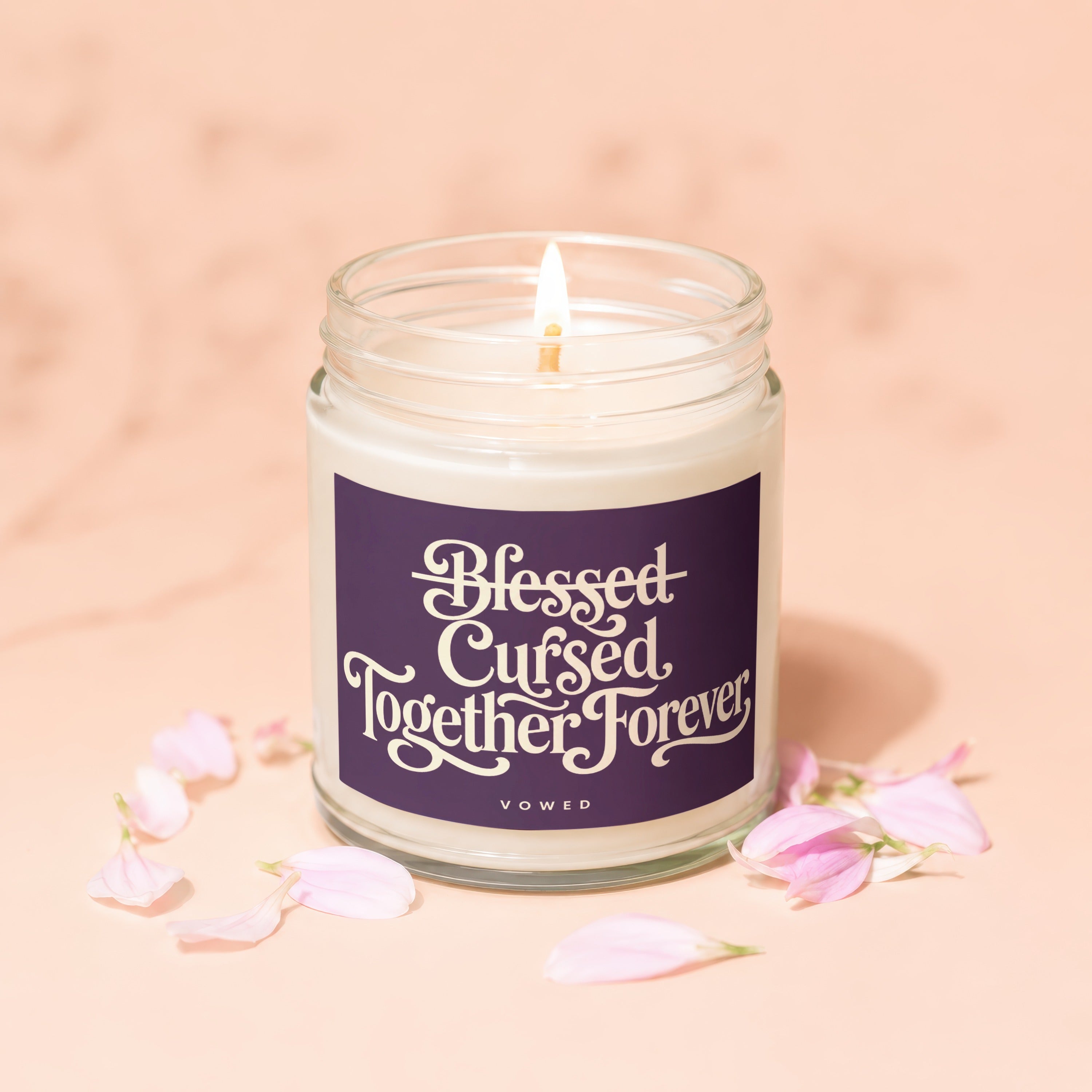 Glass jar candle with "Blessed Cursed Together Forever" and "Vowed" text.
