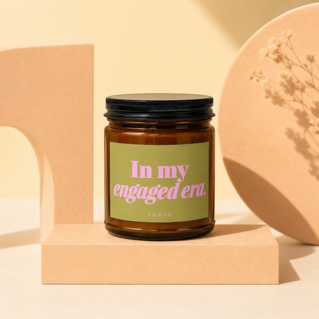 Brown candle in amber jar with green label stating "In my engaged era. VOWED."