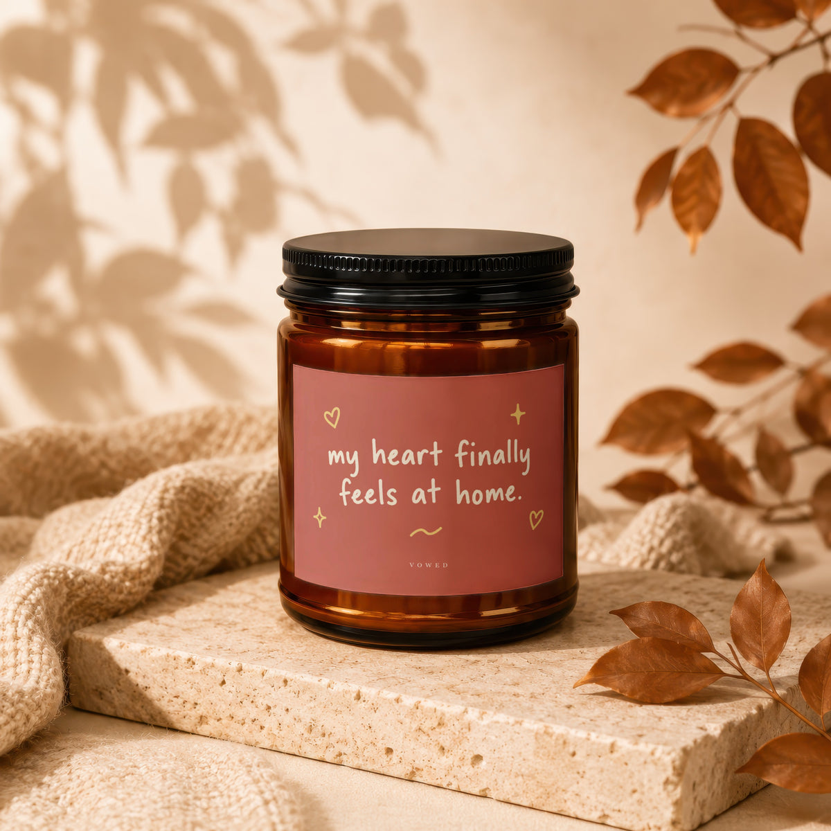 Amber jar candle with pink label reading "my heart finally feels at home."