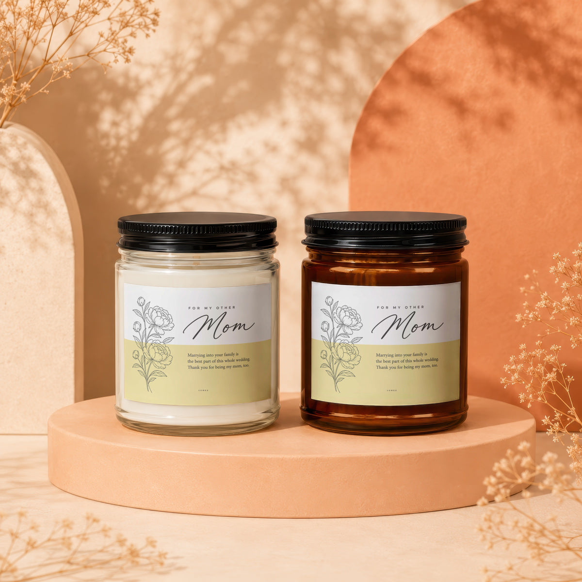 Two candles, one clear and one amber, with "Mom" labels and floral designs.