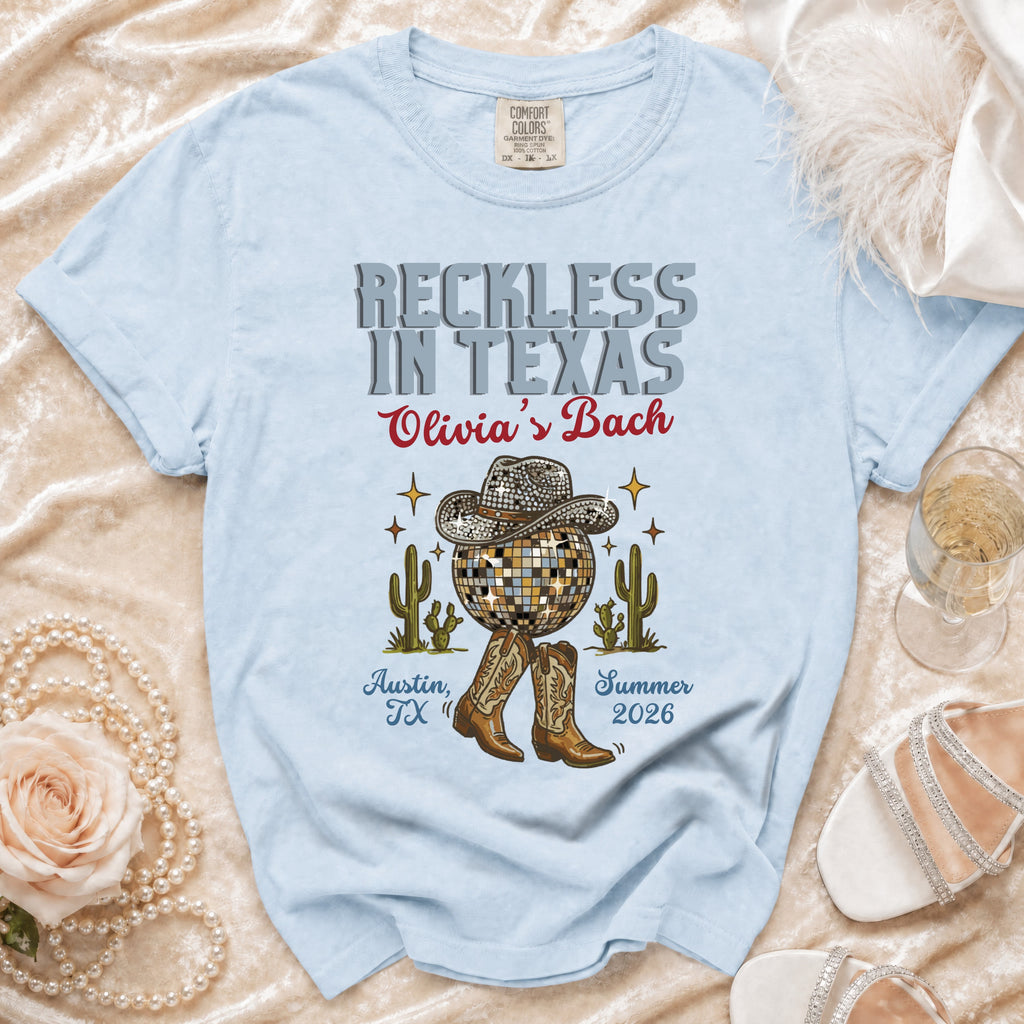 Light blue t-shirt with "Reckless in Texas Olivia's Bach" design.