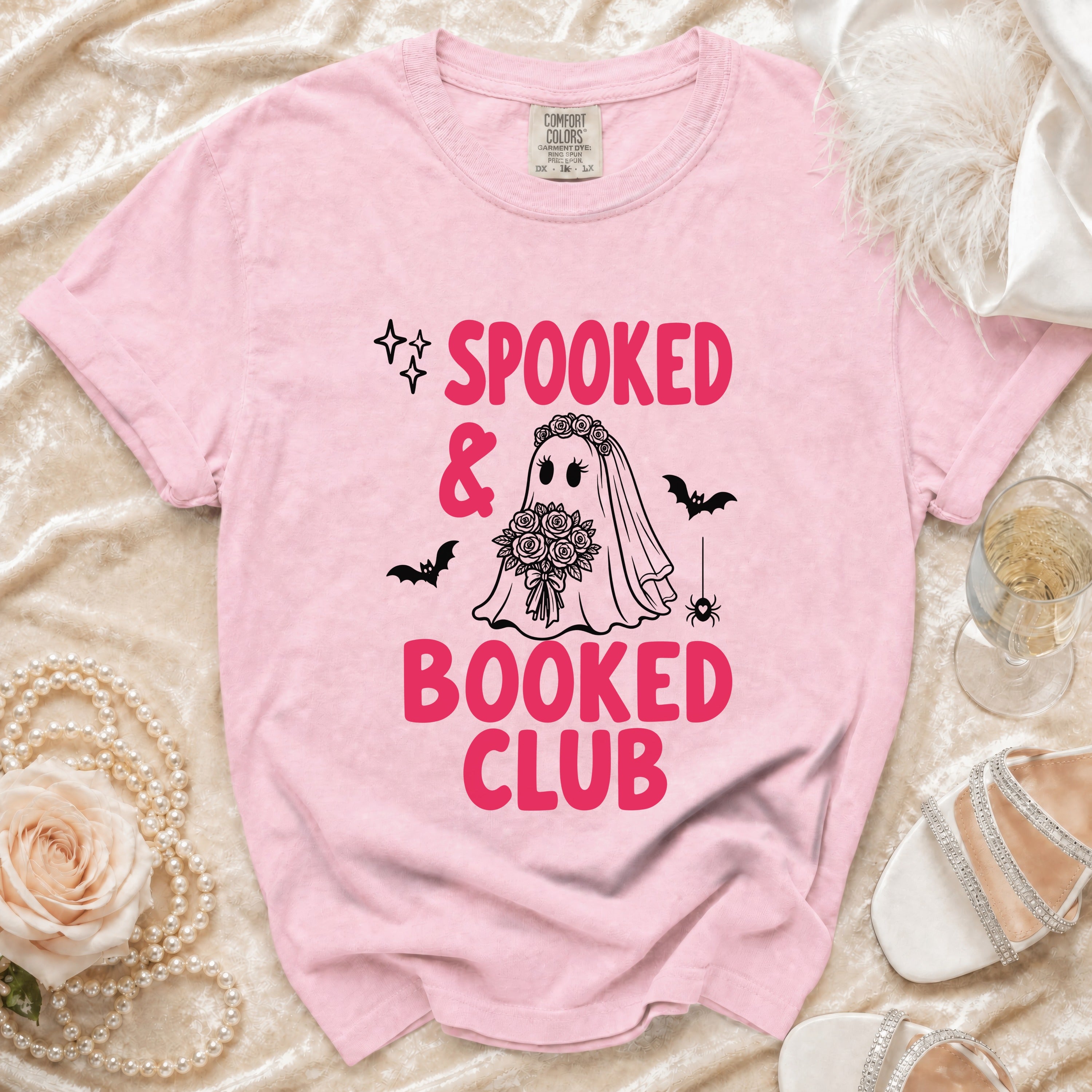 Pink t-shirt with "Spooked & Booked Club" graphic and bride ghost.