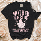Black t-shirt with pink "Mother of the Bride Raising Hell Since Day One" graphic.