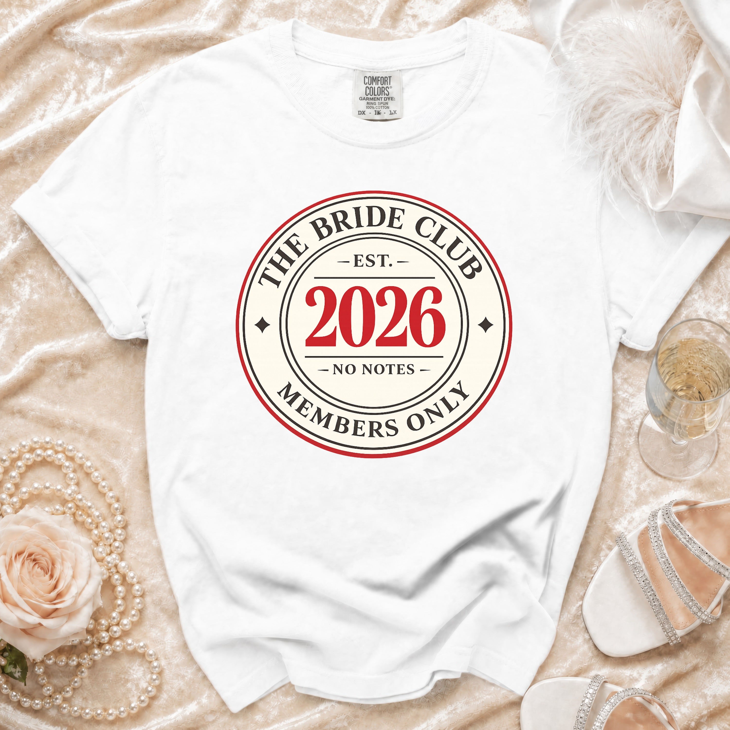 White t-shirt with "The Bride Club Est. 2026 Members Only" graphic.